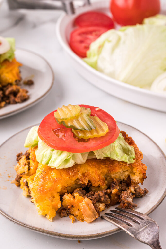 cheeseburger casserole slice onplate with lettuce tomato and pickles