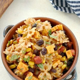 looking down onto a clay bowl filled with taco pasta salad