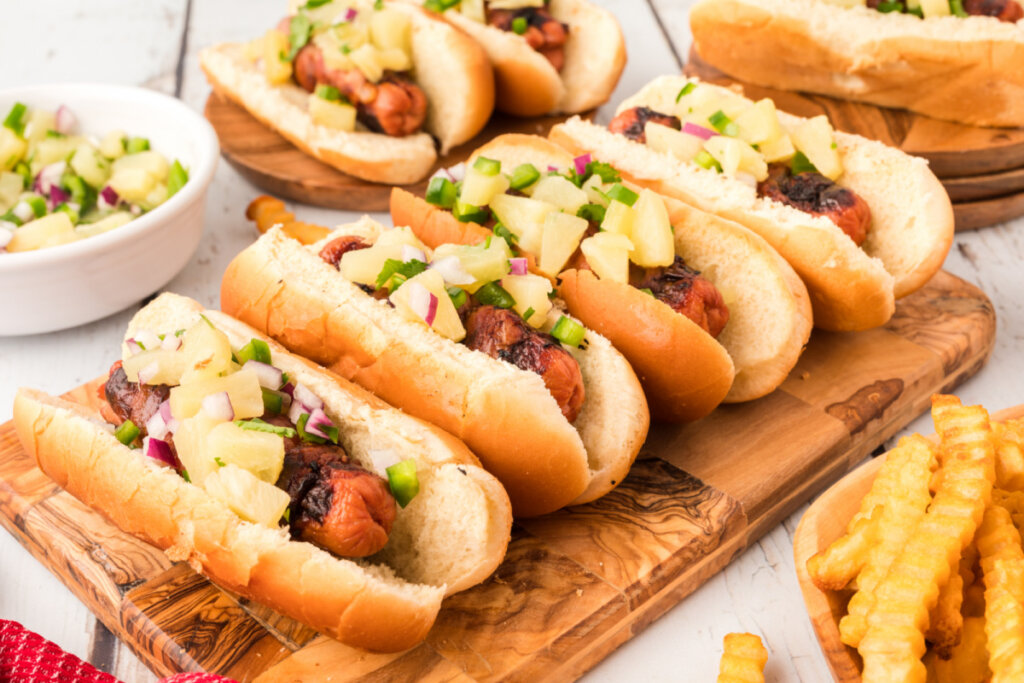 four hawaiian hot dogs on wooden board