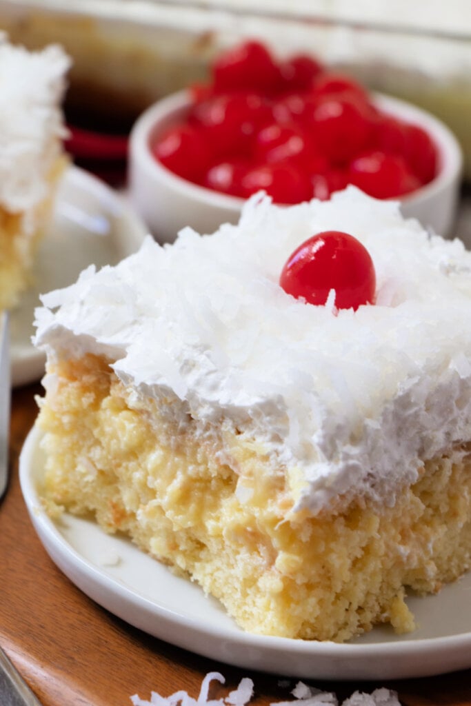 pina colada poke cake slice on white plate