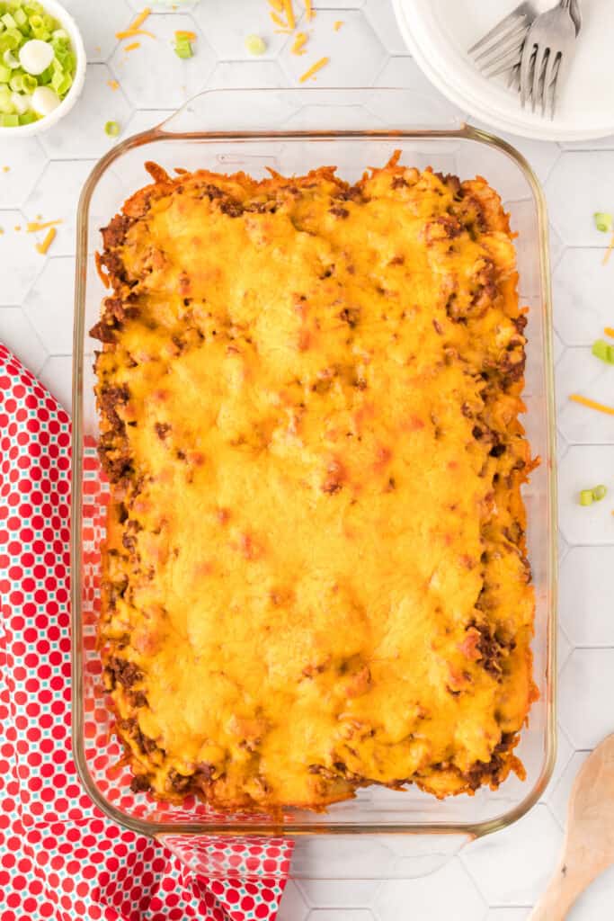 Baked Chili Cheese Tater Tot Casserole topped with melted cheddar cheese in a glass baking dish.