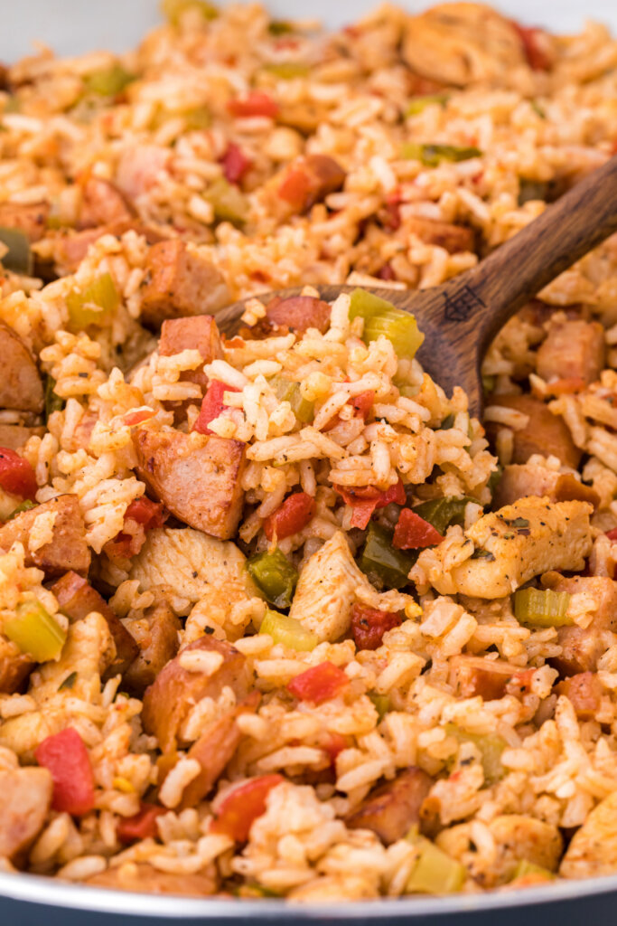 closeup of jambalaya being scooped with wooden spoon