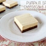 Pumpkin Spice Cheesecake Bar on plate with bars in the background.