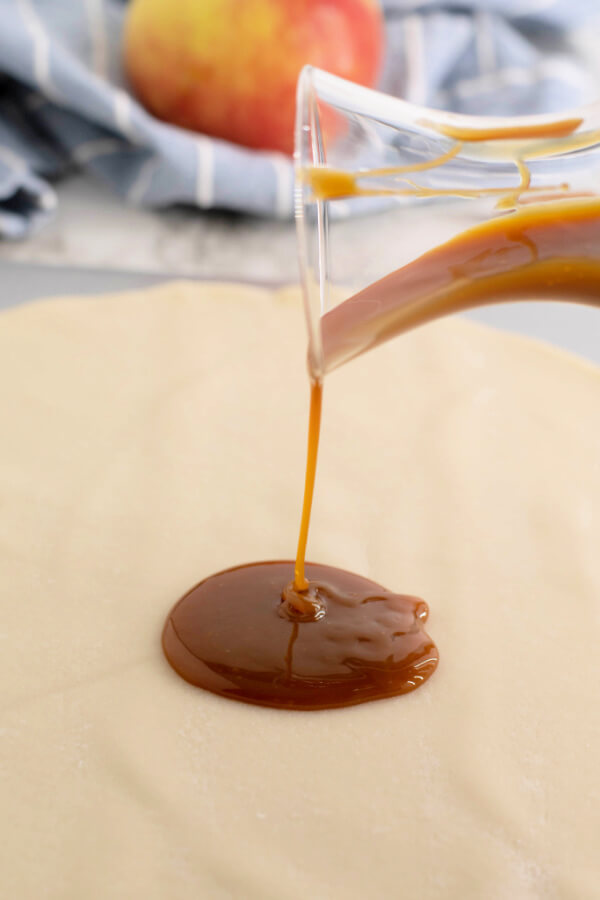 pouring caramel sauce onto pie crust