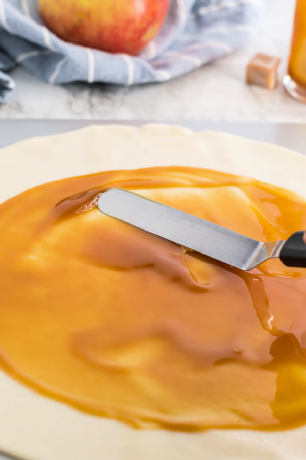 spreading the caramel out iwth an offset spatula