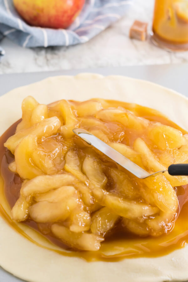 spreading apple pie filling over the caramel