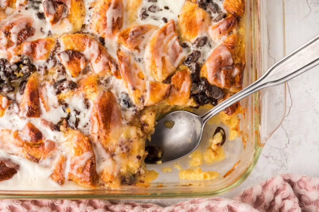 cinnmoan roll bread pudding in pan with spoon