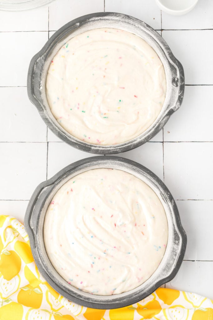 Lemon Funfetti Cake batter in greased and floured pans