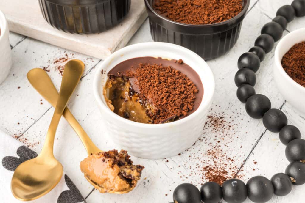 Cappuccino Crème Brûlée with creamy espresso custard, chocolate topping, and finely ground espresso garnish served with gold spoons