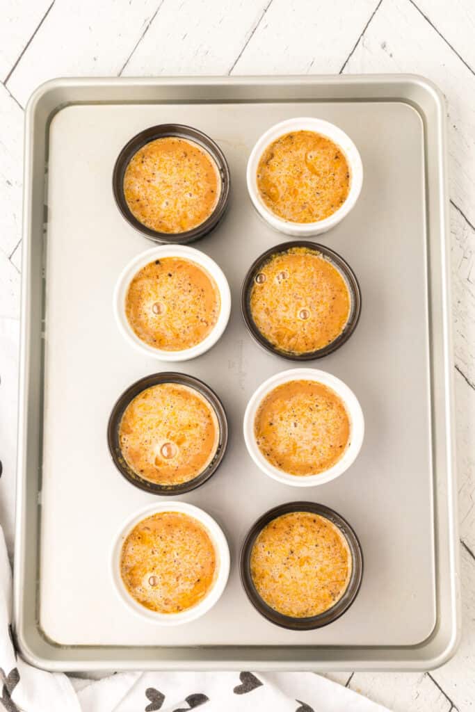 Unbaked Cappuccino Crème Brûlée ramekins arranged on a baking sheet
