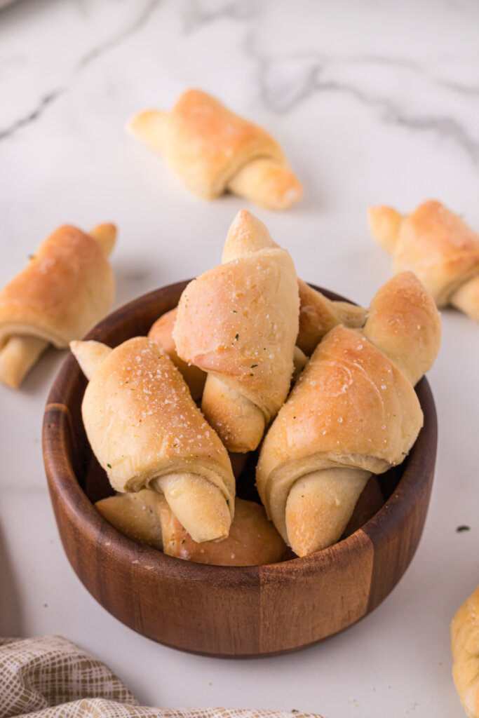 crescent rolls in wooden bowl on marble background