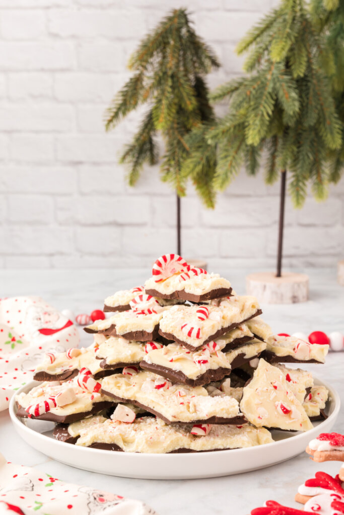 christmas peppermint bark on plate with small trees in background