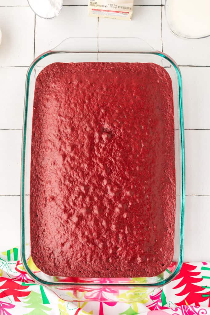 Baked red velvet cake in a 9x13-inch glass baking dish before poking holes.