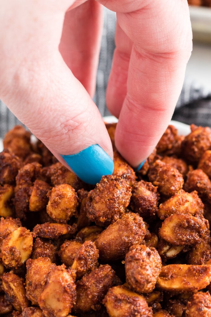 hand reaching into a bowl of nuts