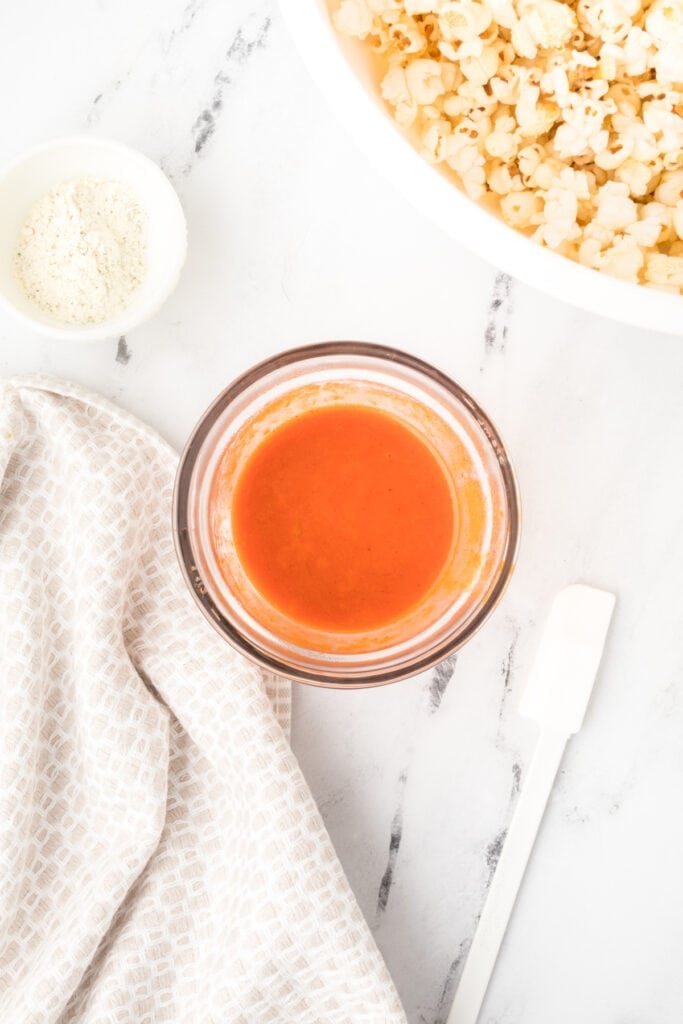 Mixed buffalo sauce and butter mixture for Buffalo Ranch Popcorn recipe