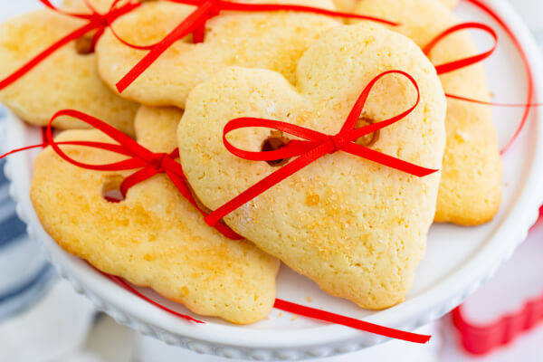 Cookies with ribbon around them on a cake stand.