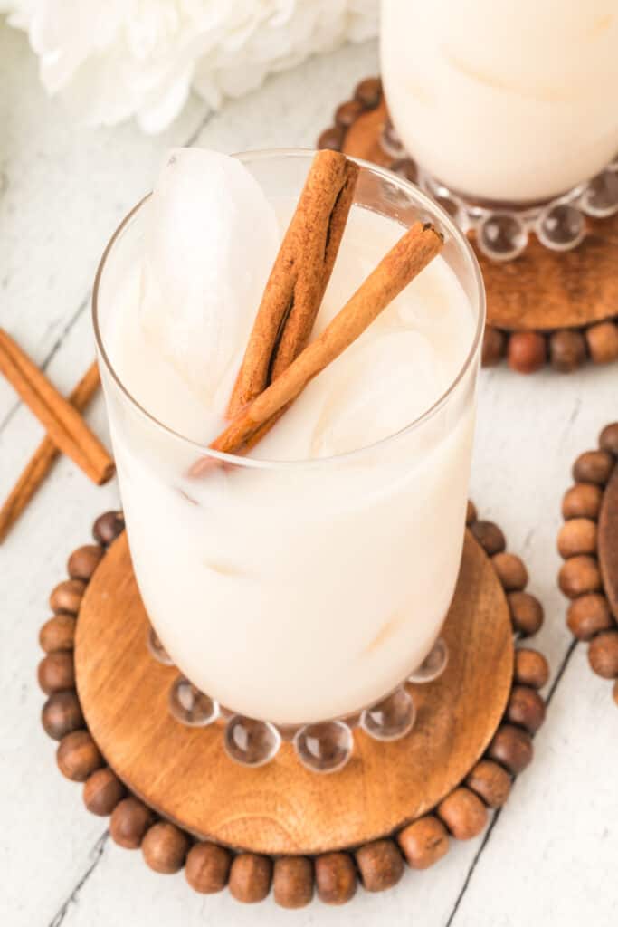 glass of horchata garnished with cinnamon sticks