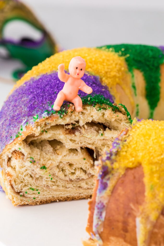 closeup of plastic baby in mardi gras cake