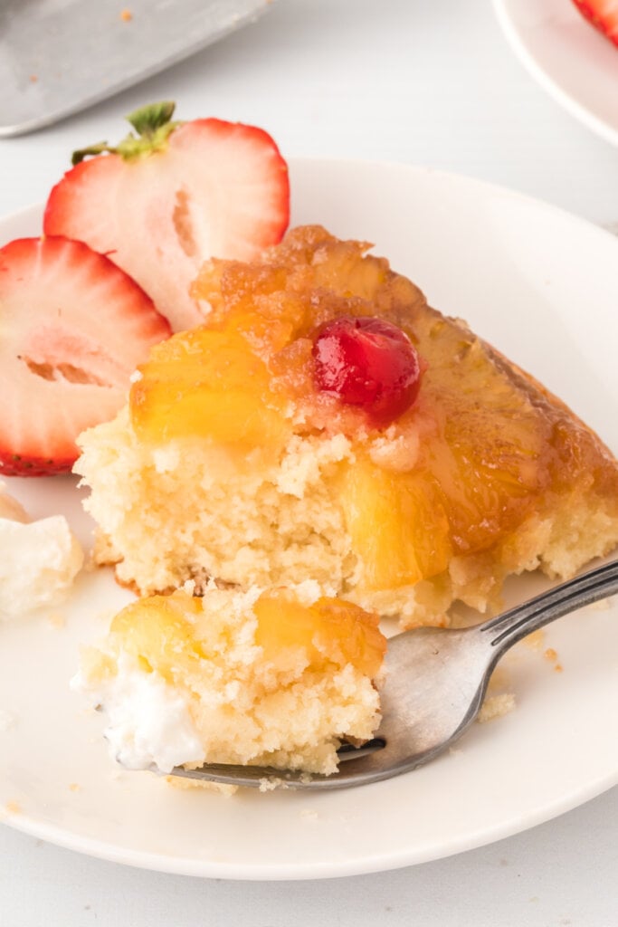 bite of pineapple upside down cake on fork on plate