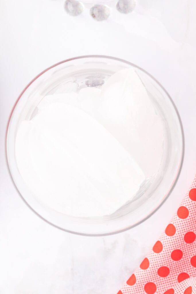 clear glass filled with large ice cubes on a white surface