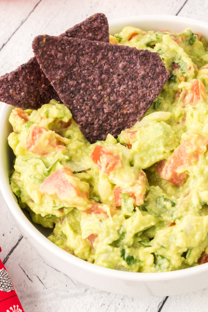 two chips in a bowl of homemade guacamole