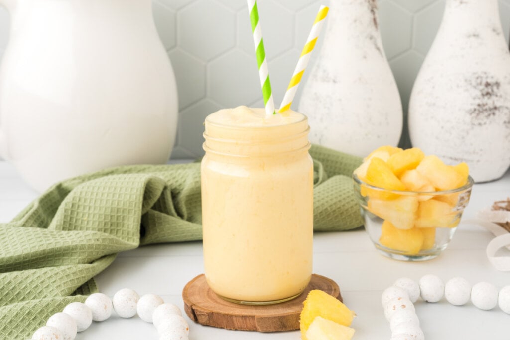 pineapple orange smoothie on wooden coaster