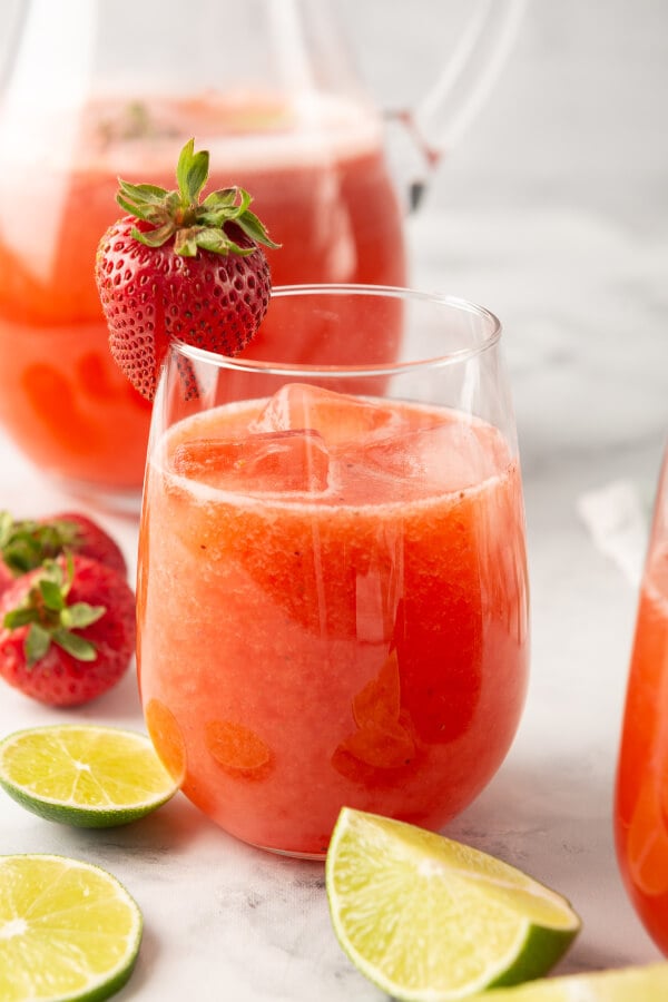 glass of strawberry agua fresca garnished with a strawberry