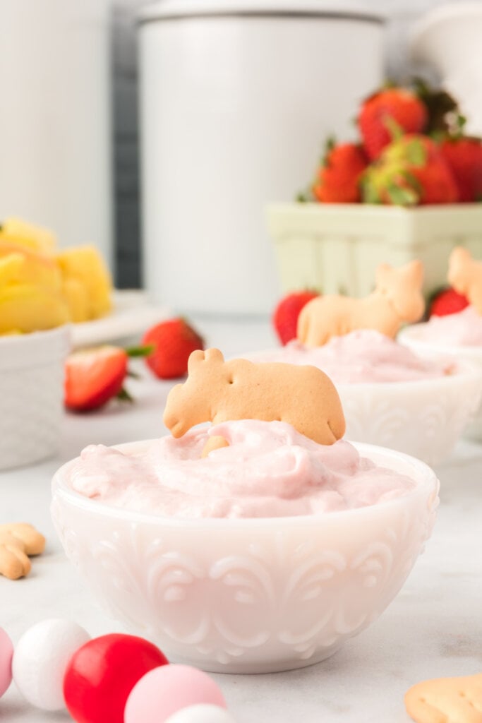 animal cracker in strawberry cream cheese dip