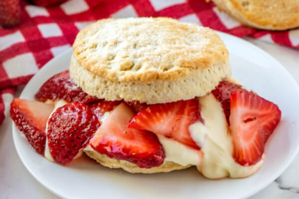 closeup of strawberry shortcake with lemon cream sauce on plate