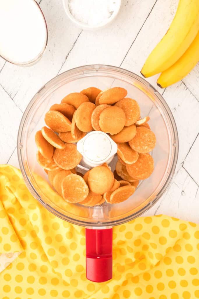 Nilla wafers in a food processor ready to be crushed for banana pudding parfait