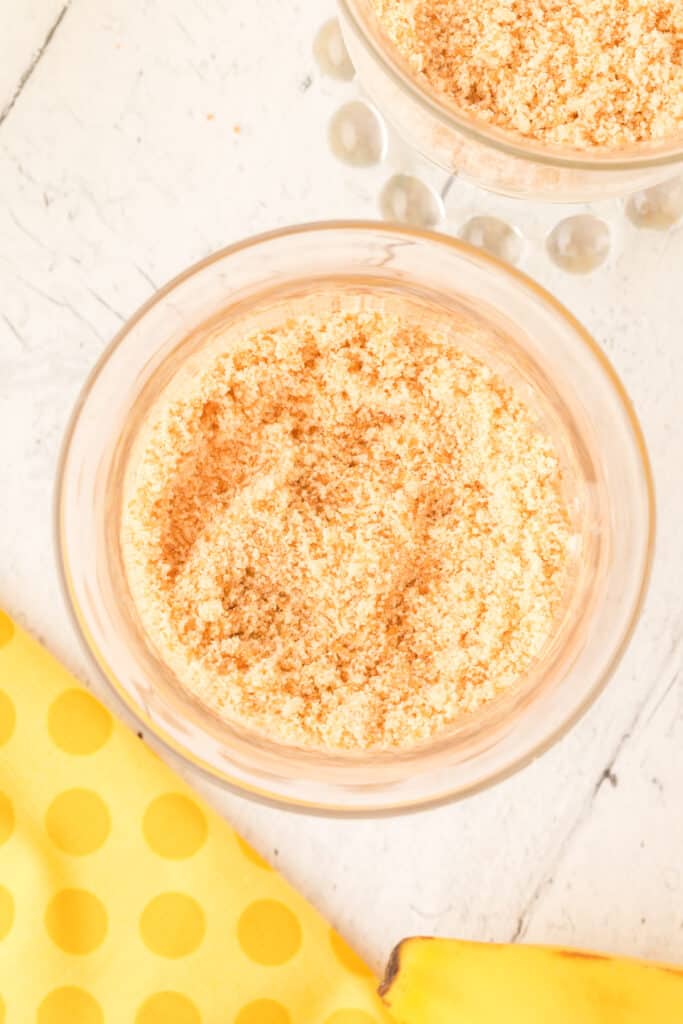 cookie crumbs layered into a banana pudding parfait cup