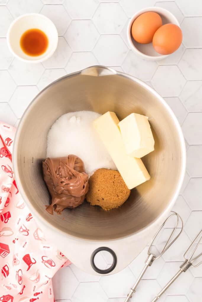 Butter, Nutella, granulated sugar, and brown sugar in a mixing bowl for making Chocolate Blossoms