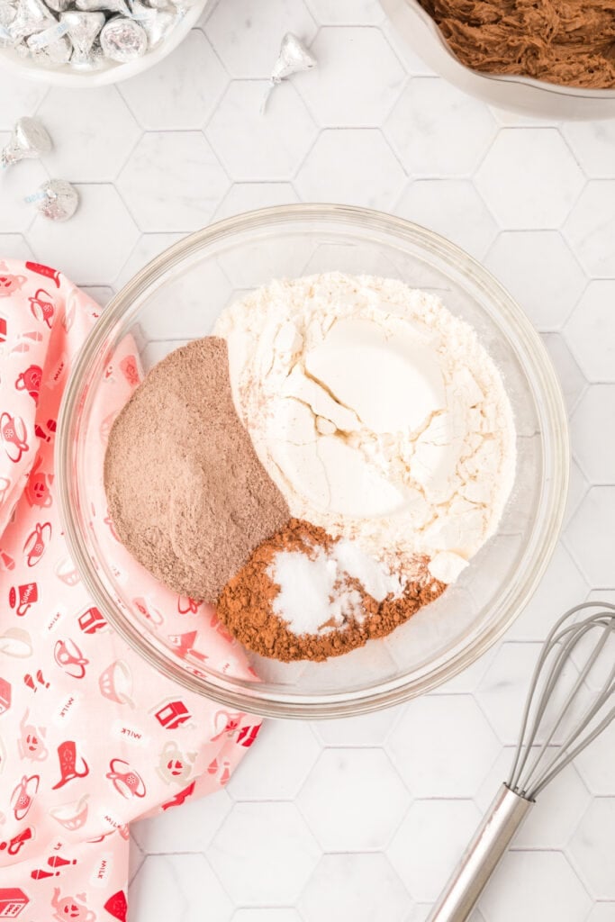 Flour, chocolate pudding mix, cocoa powder, baking soda, and salt combined in a glass bowl for Chocolate Blossoms