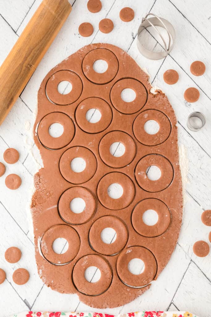 Rolled dough with chocolate cinnamon doughnuts cut out, ready to fry.