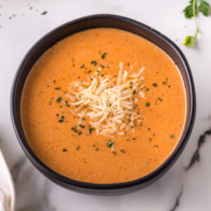 creamy tomato soup in black bowl