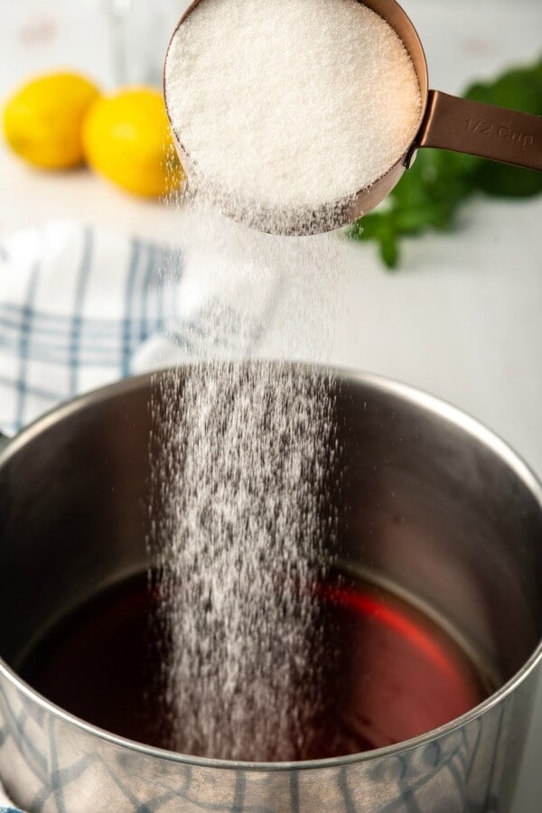 sugar being poured into brewed tea