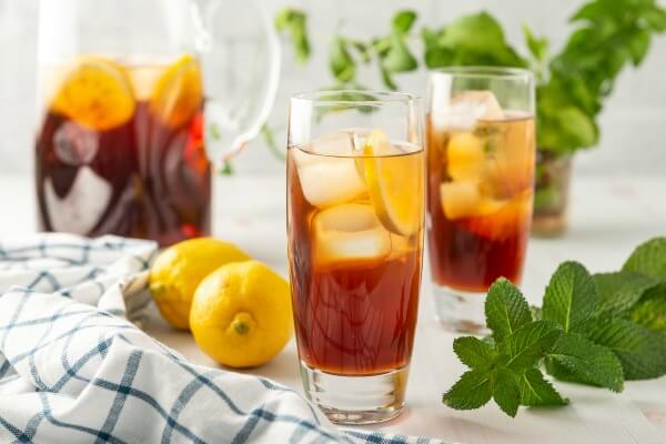 two glasses of sweet tea with pitcher of tea in background