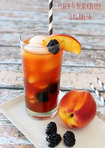 Jose Cuervo Iced Teagarita consists of the classic limeA Peach and Blackberry Teagarita in a glass with a peach next to the glass.