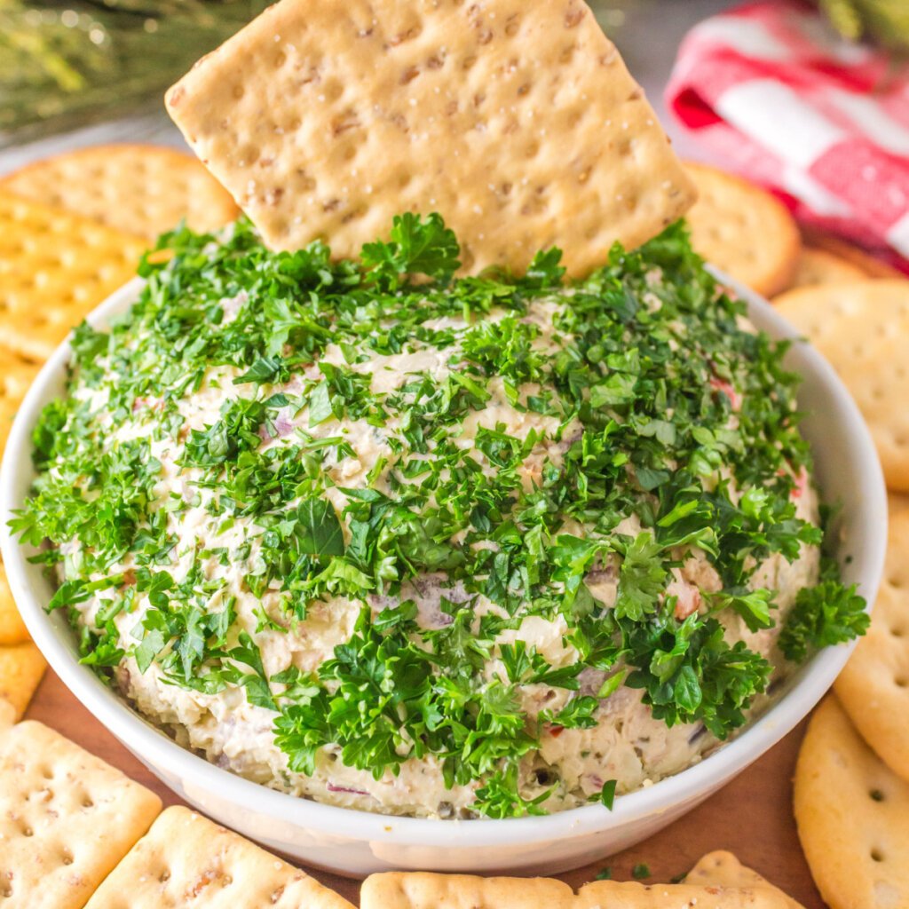 bacon pesto cheese ball dip in bowl with crackers