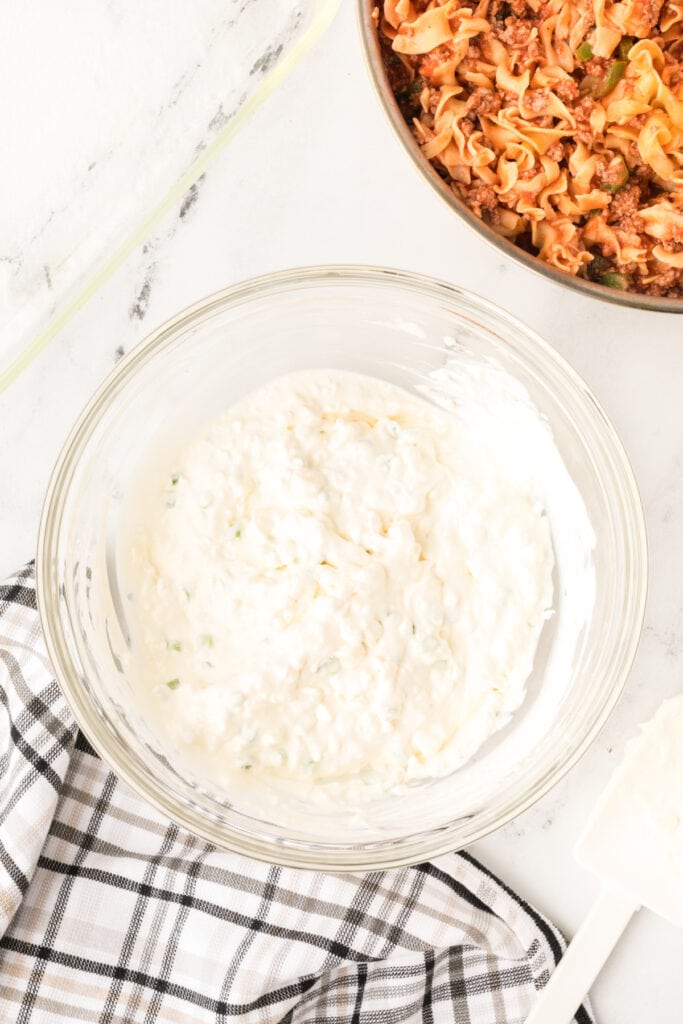smooth cottage cheese mixture with green onions fully combined in a glass bowl