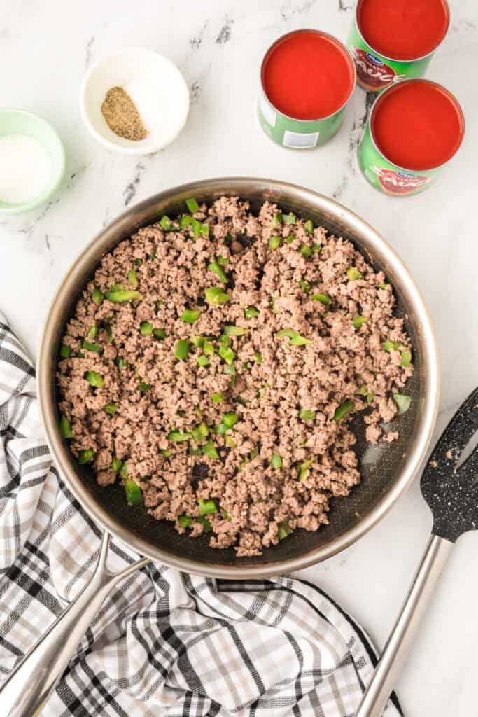 browned ground beef and green pepper mixture cooking in a skillet