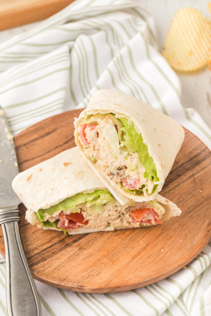 blt avocado chicken salad wraps cut in half on wooden cutting board