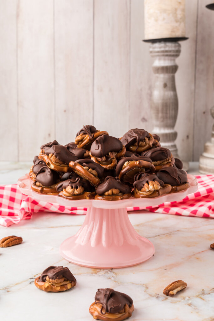 chocolate turtle candy stacked on pink cake platter