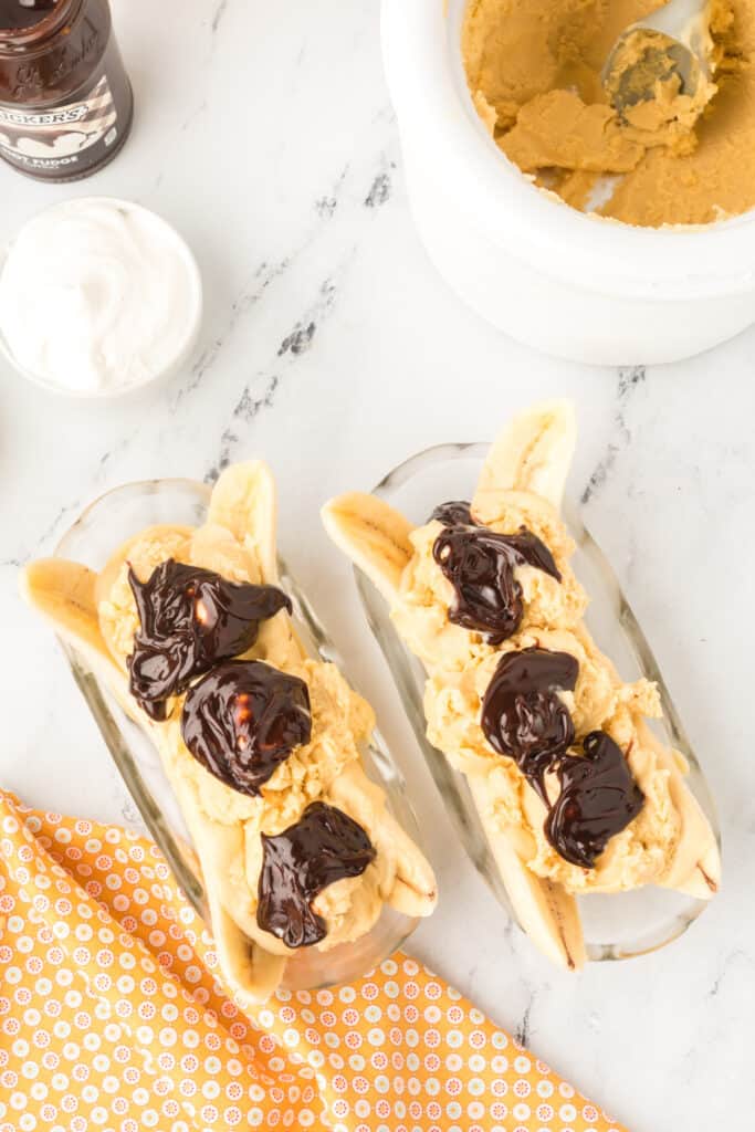 Hot fudge sauce spooned over homemade peanut butter ice cream on an Elvis Banana Split.