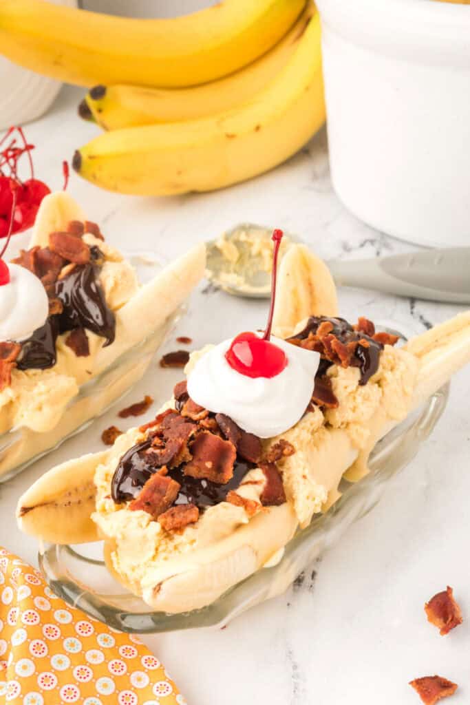 Elvis Banana Split made with homemade peanut butter ice cream, hot fudge sauce, crispy bacon, whipped cream, and a maraschino cherry.