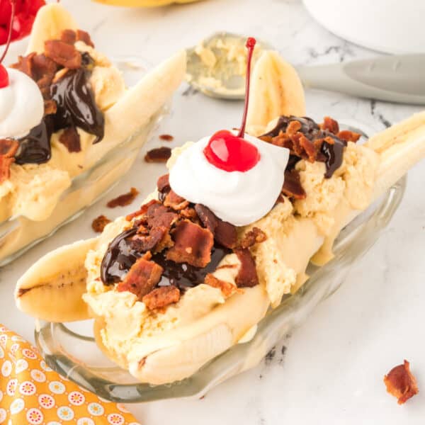 Square image of an Elvis Banana Split with peanut butter ice cream, banana, hot fudge, bacon, whipped cream, and a cherry.