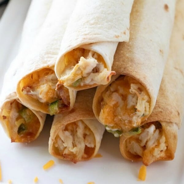 closeup of jalapeno popper chicken taquitos on plate