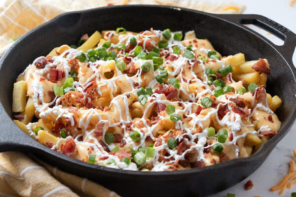 finished cheesy fries in cast iron skillet