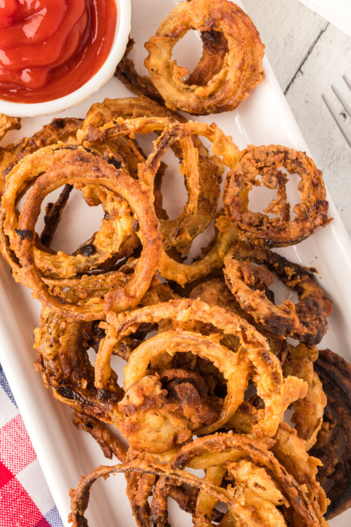 crispy onion rings on plate with ketchup