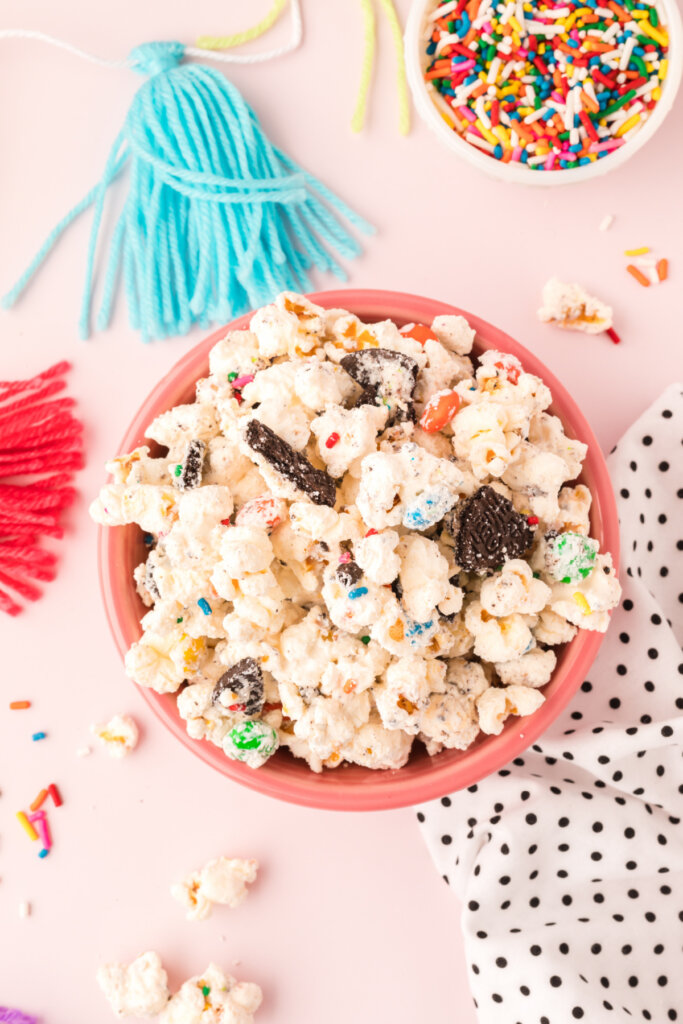 pink bowl filled with birthday cake popcorn mix